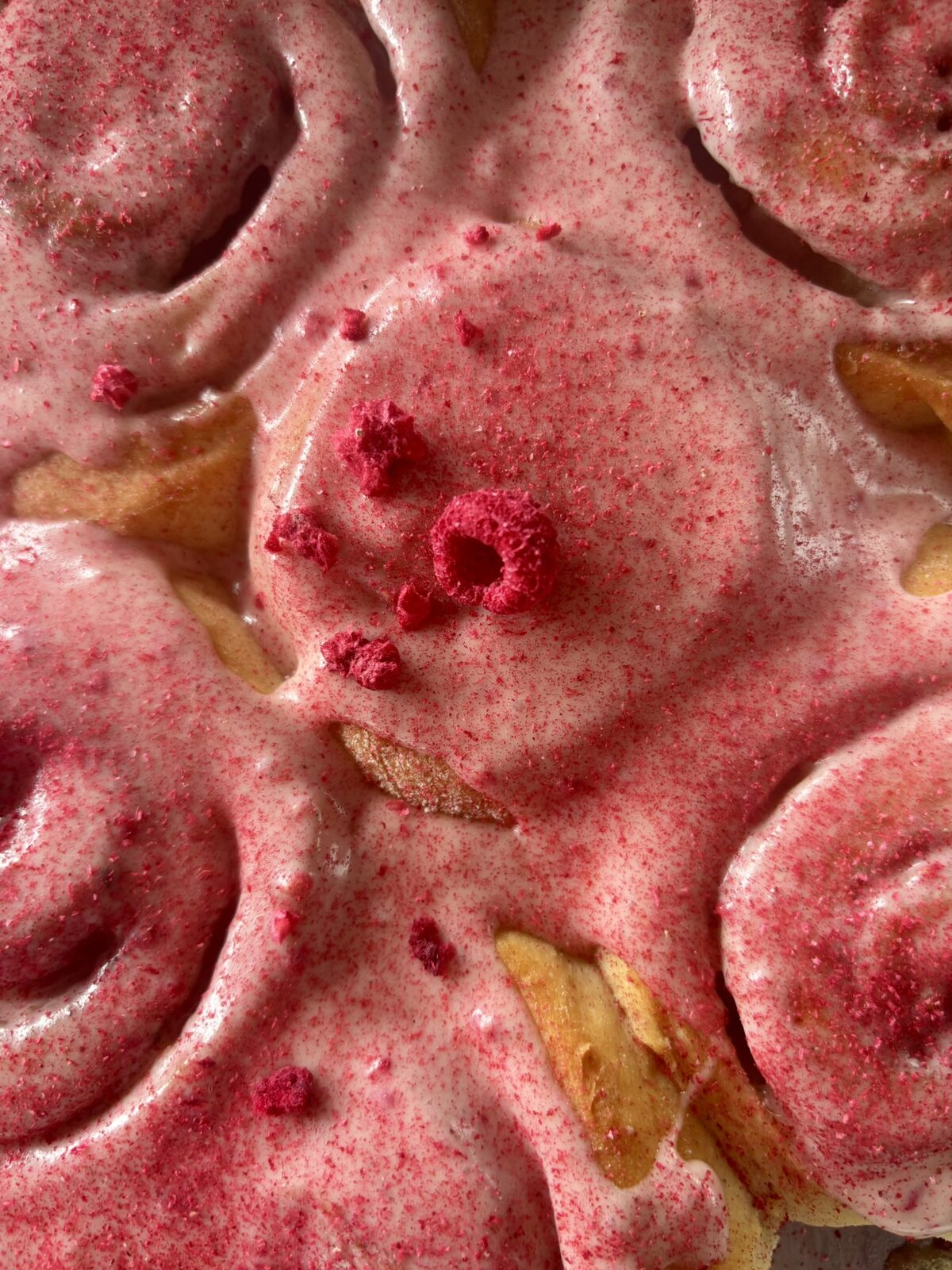 Vegane Cinnamon Rolls mit rosa Himbeer-Guss und gefriergetrockneten Himbeeren